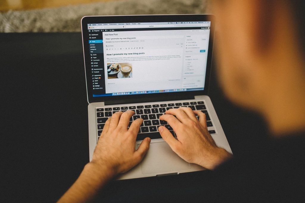 guy with his hands on the keyboard of his laptop